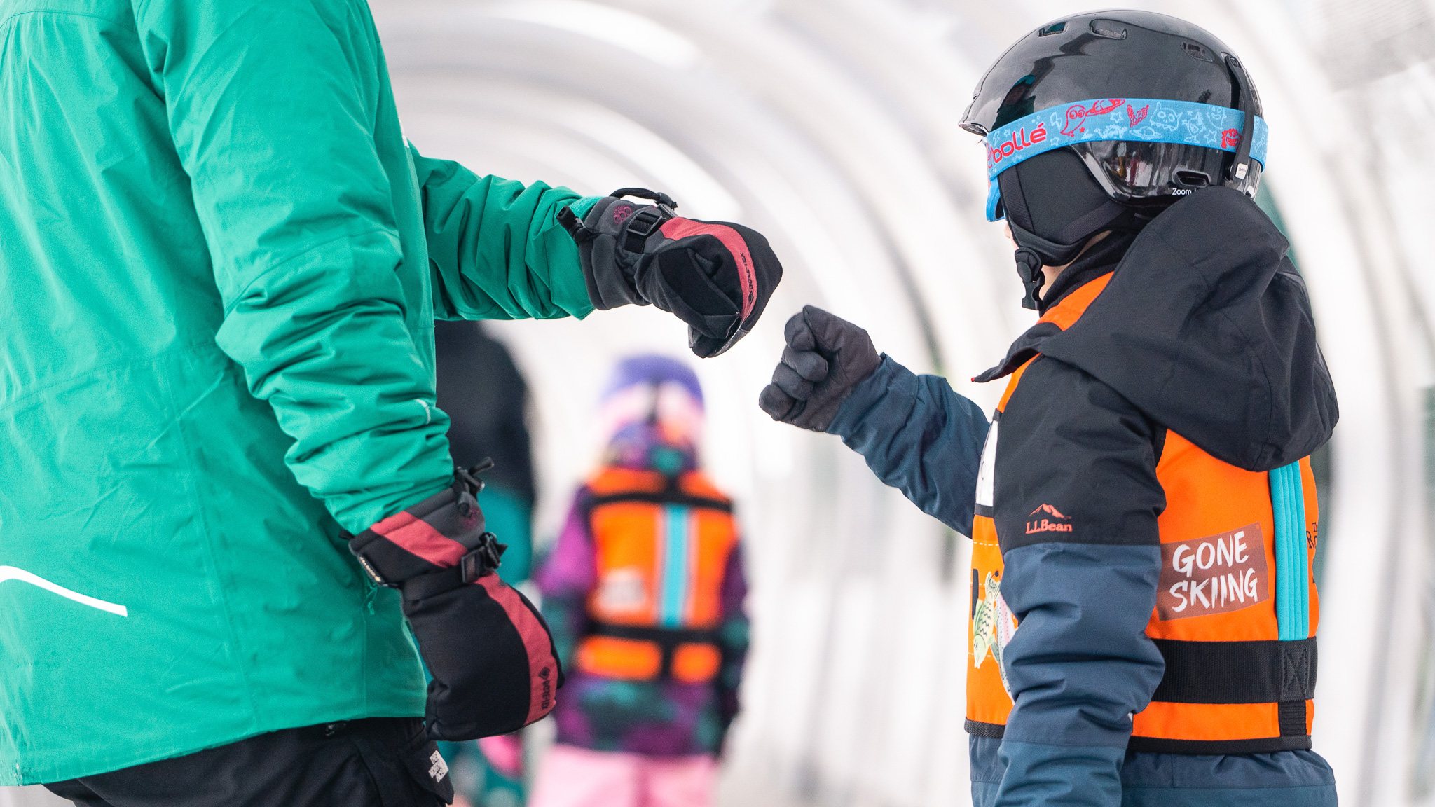 Ski lesson fist bump on moving carpet