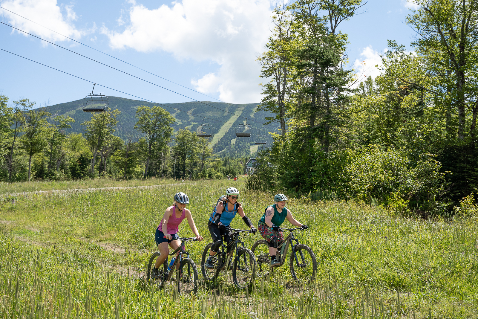 Three female bike riders in a field